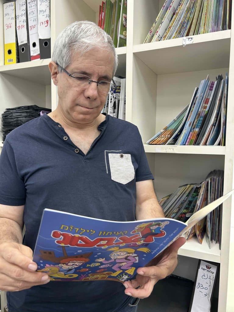 רמי שיר, העורך הראשי והבעלים של הוצאת אצבעוני, קורא בגיליון של עיתון הילדים "אצבעוני" במשרדי ההוצאה.