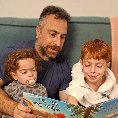 ארז חן יושב עם ילדיו וקורא להם מתוך ספר הילדים שכתב, "ברי בר נשאר ער" — רגע משפחתי חמים של קרבה, חיוך ואהבה ללא תנאי.